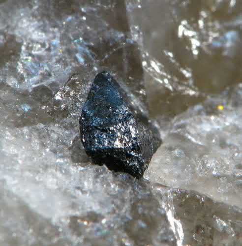 FIGURE 5. Wodginite, Mn21Sn41Ta2O8, 1 2 mm black euhedral crystal in matrix.